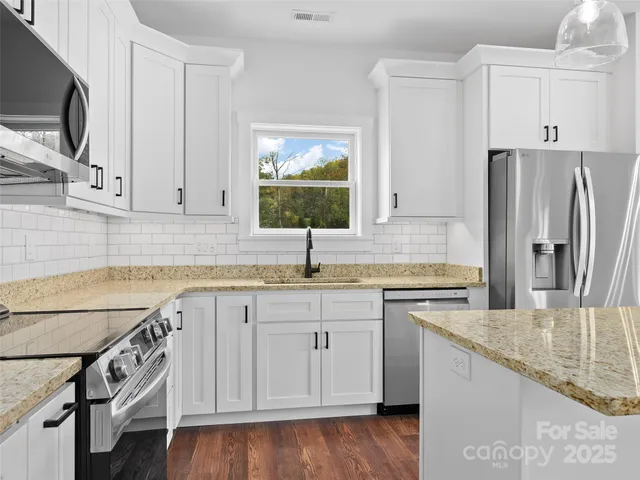 a kitchen with a refrigerator a stove top oven and kitchen island