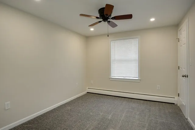 an empty room with a window and a ceiling fan