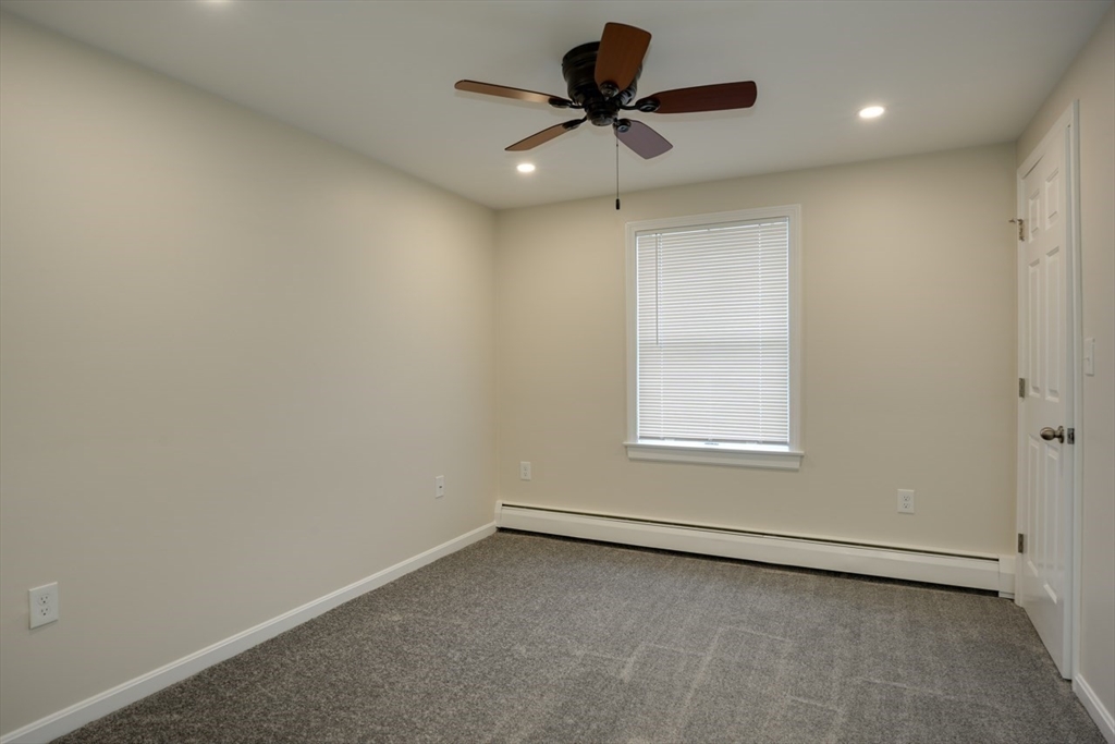 49 Douglas Avenue, Unit 49 Maynard, MA 01754 - Photo 12 of 23 an empty room with a window and a ceiling fan
