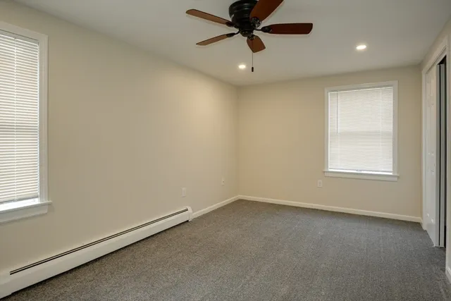 an empty room with a window and a fan