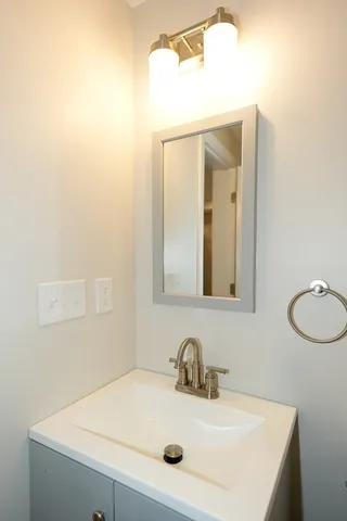 a bathroom with a sink vanity and mirror