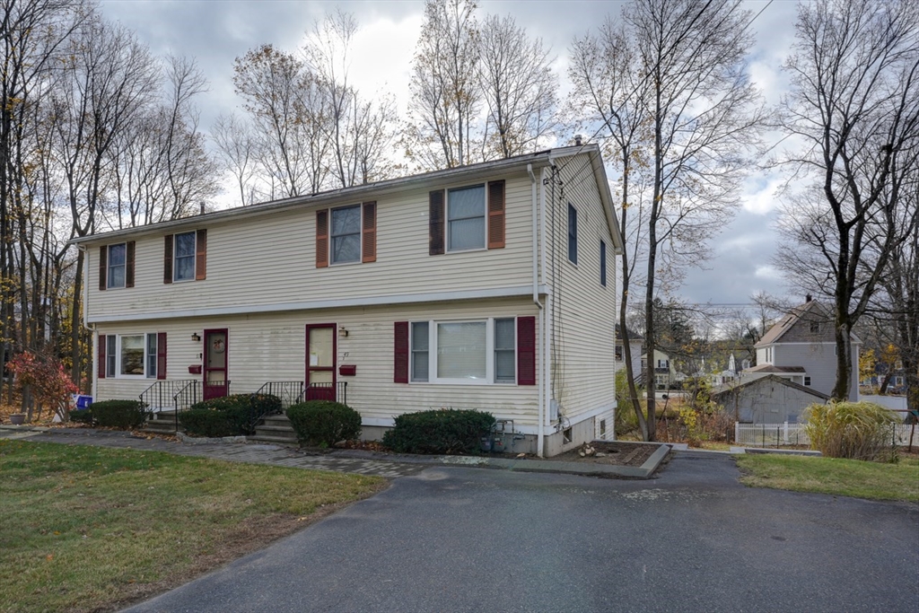 49 Douglas Avenue, Unit 49 Maynard, MA 01754 - Photo 23 of 23 a front view of a house with a yard and garage