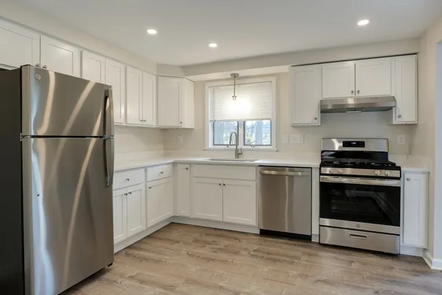 a kitchen with stainless steel appliances a refrigerator sink and cabinets