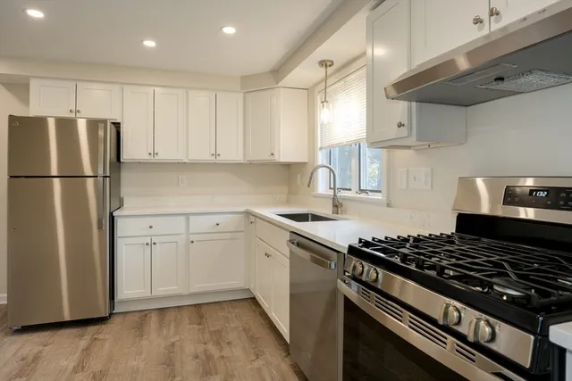 a kitchen with a stove a refrigerator and a sink