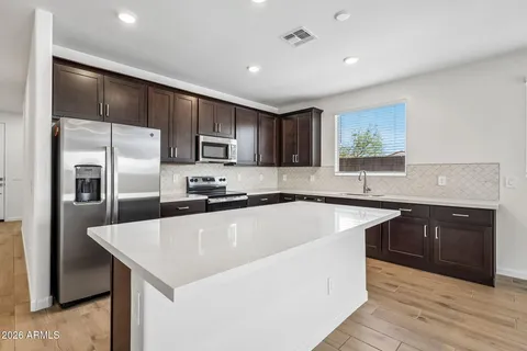 a kitchen with kitchen island a sink stainless steel appliances and cabinets