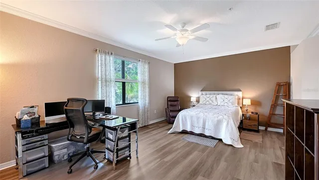 a bedroom with a bed and wooden floor