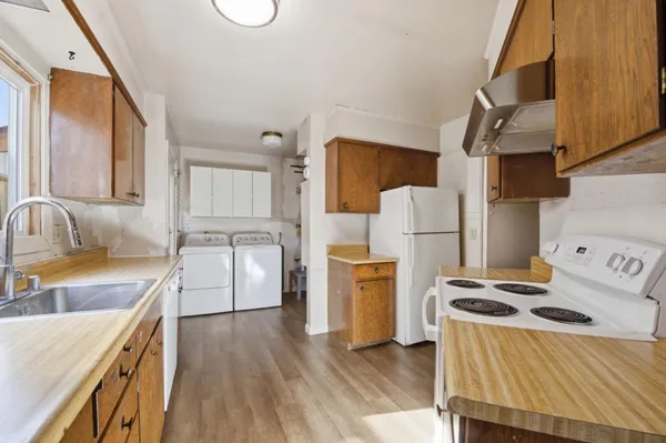 a kitchen with granite countertop a sink a counter space appliances and cabinets