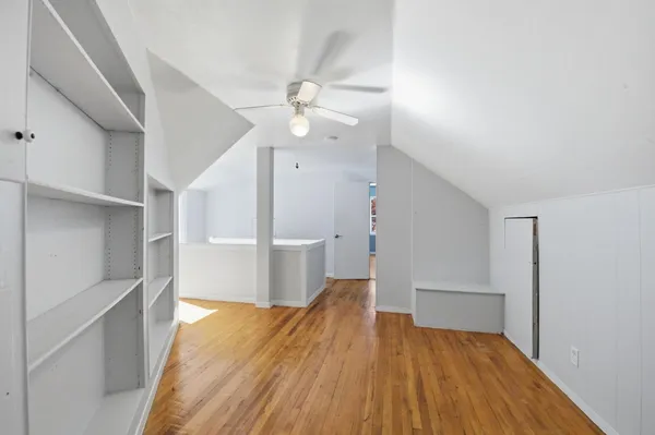 a view of a room with wooden floors and ceiling fan