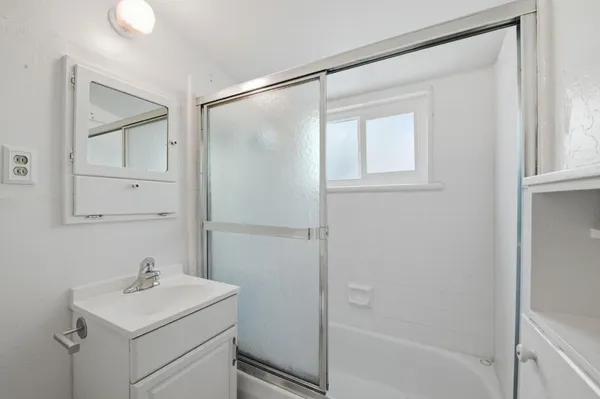 a bathroom with a sink a mirror and a shower