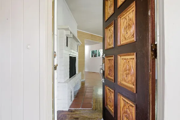 a view of a hallway with wooden floor and entryway