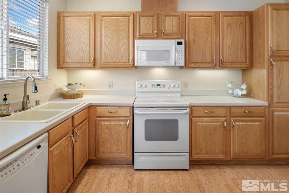 10055 Kentfield Place Reno, NV 89521 - Photo 12 of 39 a kitchen with stainless steel appliances granite countertop a sink stove and cabinets