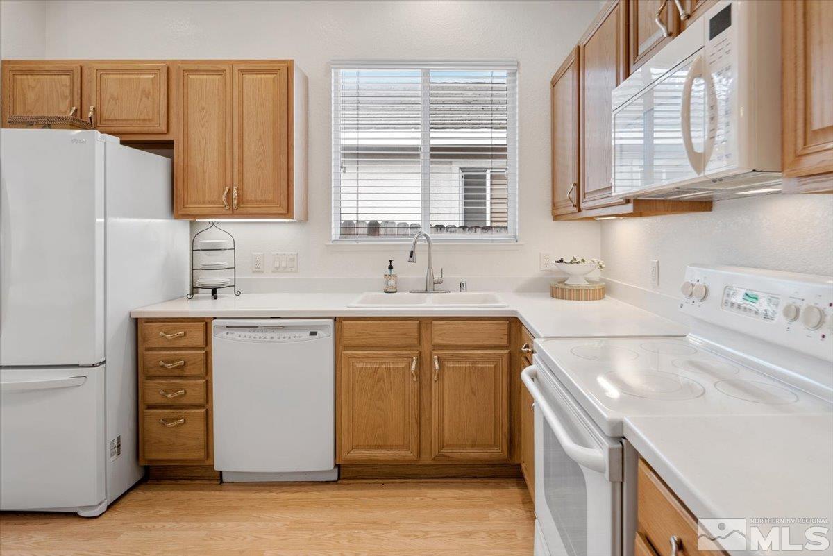 10055 Kentfield Place Reno, NV 89521 - Photo 13 of 39 a kitchen with stainless steel appliances granite countertop a sink a stove and a refrigerator