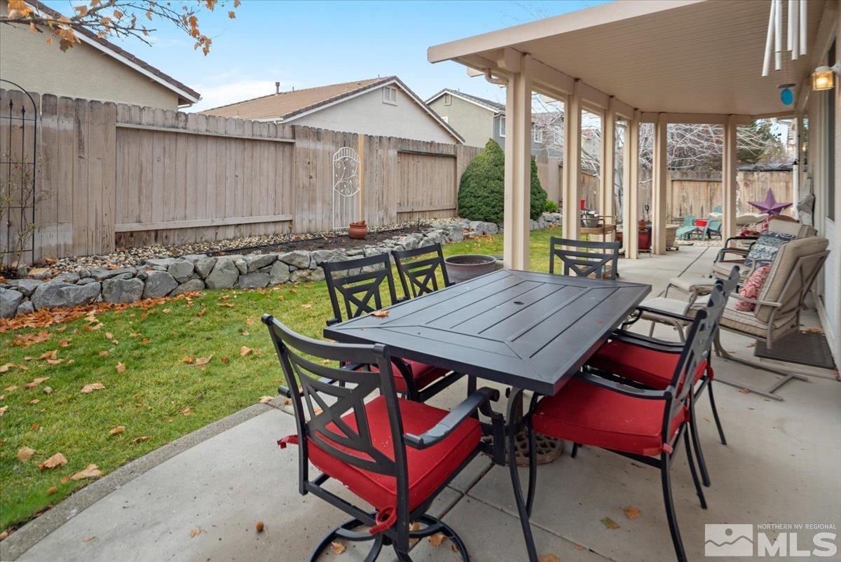 10055 Kentfield Place Reno, NV 89521 - Photo 36 of 39 a view of a patio with table and chairs with wooden floor and fence