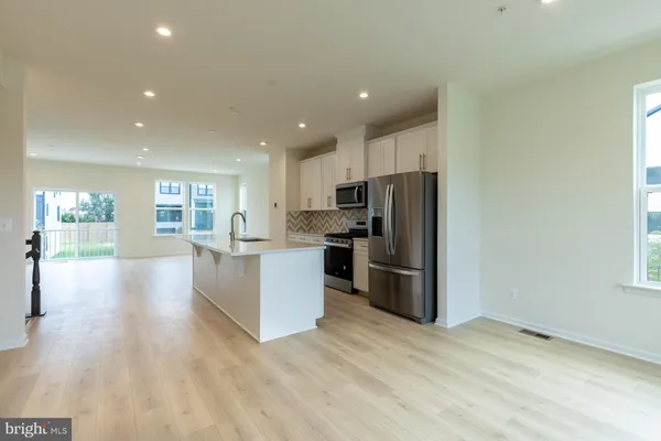 a view of a kitchen with wooden floor and electronic appliances