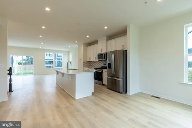 a view of a kitchen with wooden floor and electronic appliances