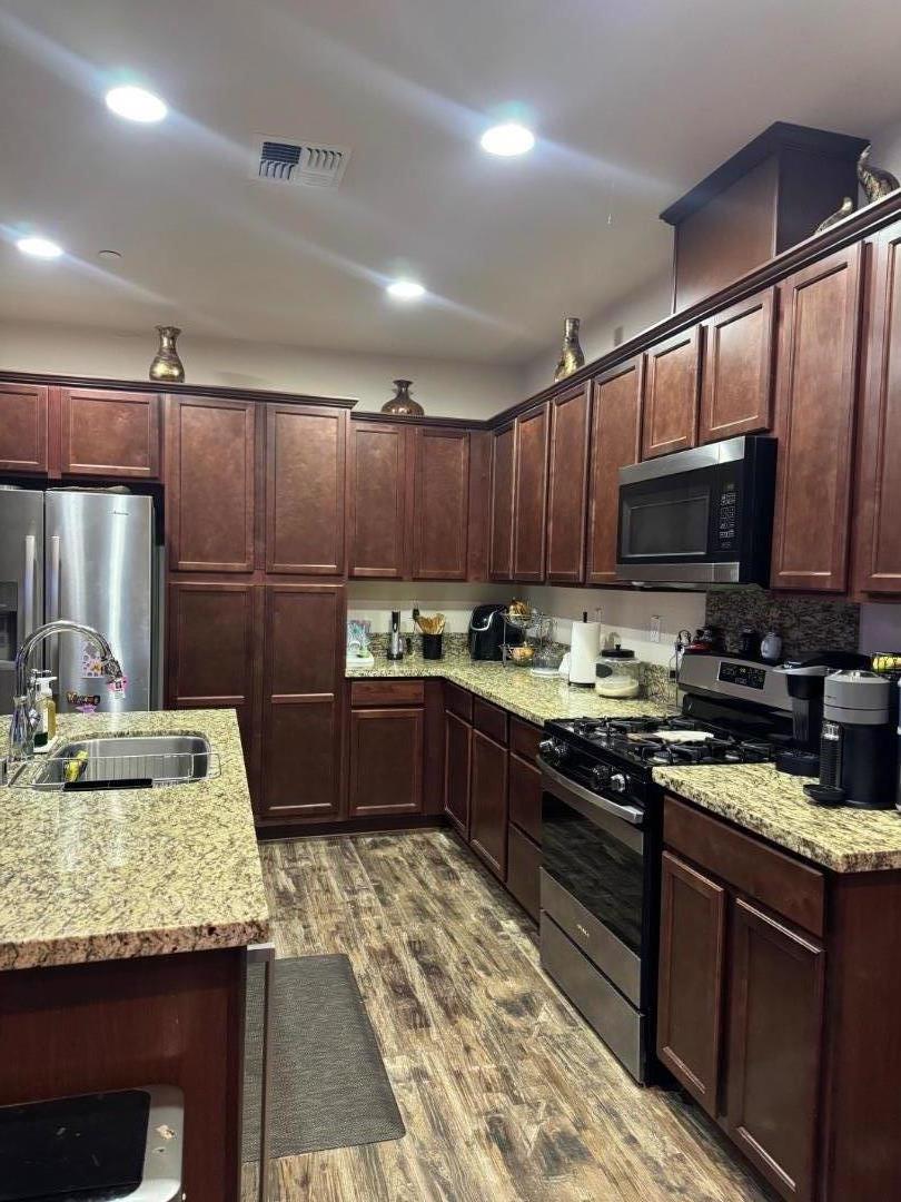 638 Robledo Drive Soledad, CA 93960 - Photo 5 of 7 a kitchen with granite countertop stainless steel appliances and wooden cabinets