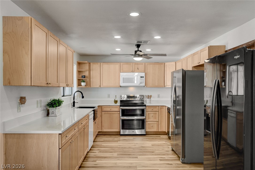 1920 Bowman Road Logandale, NV 89021 - Photo 3 of 68 Gleaming wood flooring pairs perfectly with clean countertops and classic cabinetry in this kitchen.