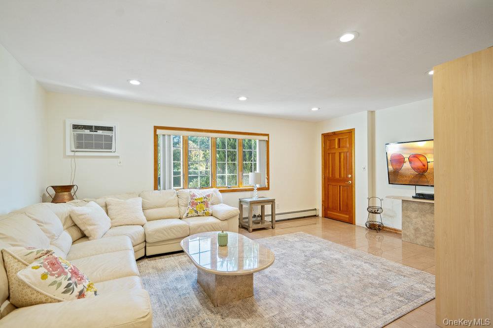 91 15th Avenue West Babylon, NY 11704 - Photo 11 of 33 a living room with furniture and a flat screen tv