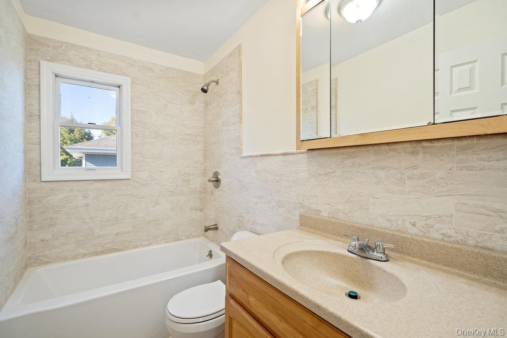 91 15th Avenue West Babylon, NY 11704 - Photo 15 of 33 a bathroom with a sink toilet and bathtub