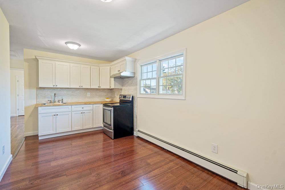 91 15th Avenue West Babylon, NY 11704 - Photo 20 of 33 a kitchen with granite countertop white cabinets and white appliances