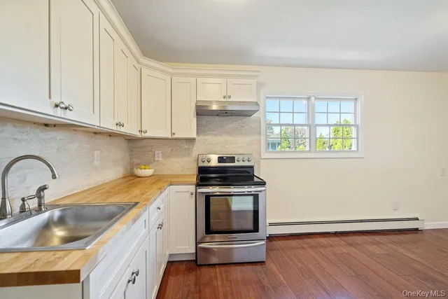 a kitchen with a sink cabinets and wooden floor