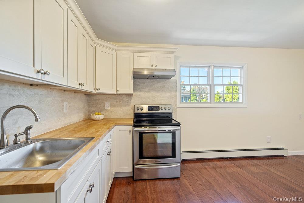 91 15th Avenue West Babylon, NY 11704 - Photo 21 of 33 a kitchen with a sink cabinets and wooden floor