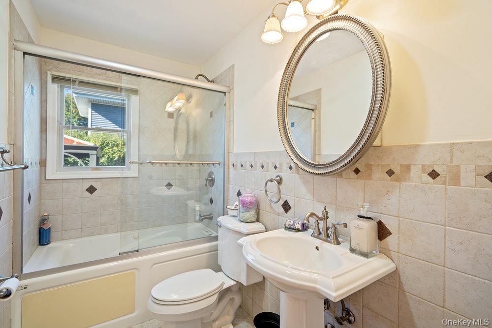 91 15th Avenue West Babylon, NY 11704 - Photo 25 of 33 a bathroom with a sink a toilet and a mirror