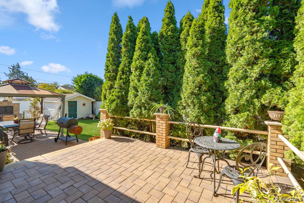 91 15th Avenue West Babylon, NY 11704 - Photo 29 of 33 a roof deck with table and chairs under an umbrella