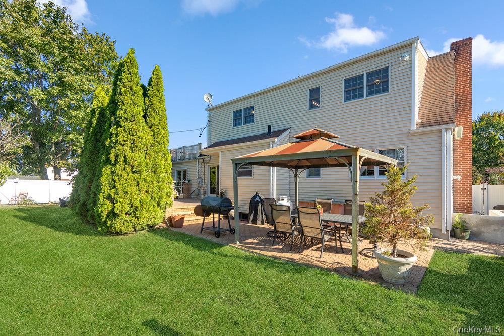 91 15th Avenue West Babylon, NY 11704 - Photo 32 of 33 a backyard of a house with a garden and outdoor seating