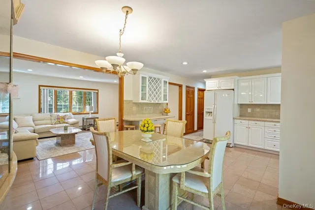 a dining room filled chandelier and kitchen view