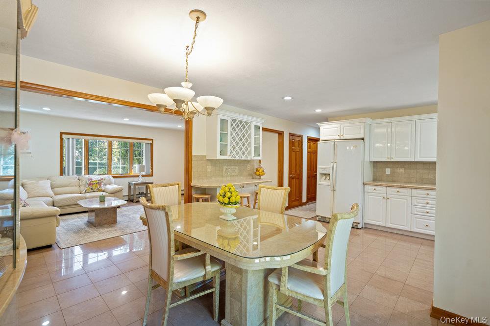 91 15th Avenue West Babylon, NY 11704 - Photo 10 of 33 a dining room filled chandelier and kitchen view