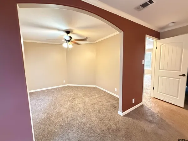 an empty room with windows and fan