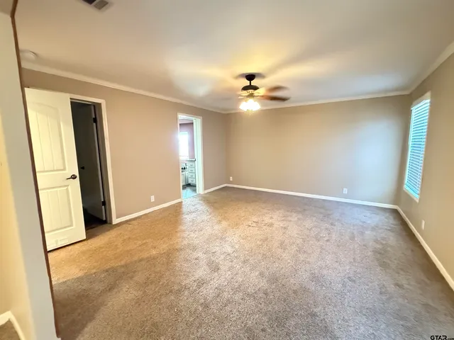 an empty room with windows and fan