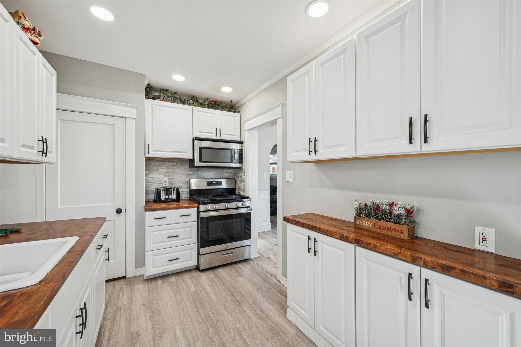 220 Sedgewood Road Springfield, PA 19064 - Photo 13 of 27 a kitchen with stainless steel appliances granite countertop a sink dishwasher stove and white cabinets with wooden floor