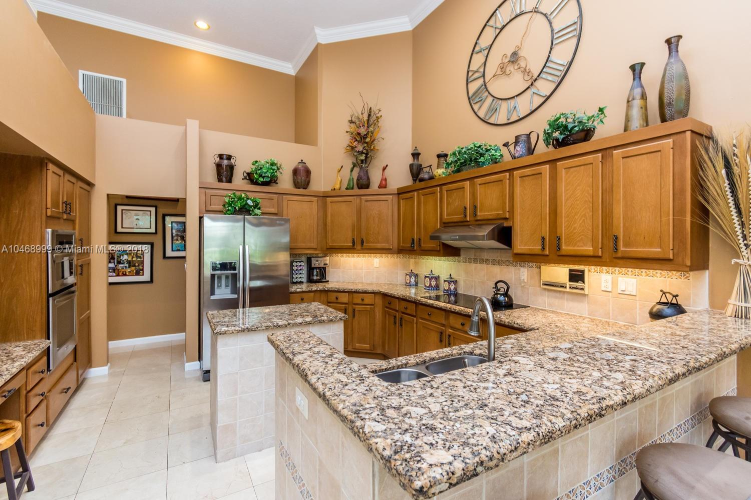 450 Alexandra Circle Weston, FL 33326 - Photo 23 of 84 a kitchen with stainless steel appliances granite countertop a sink stove and refrigerator