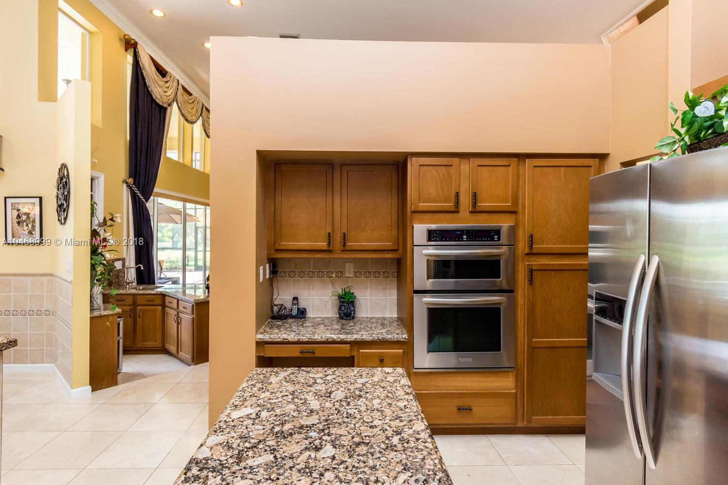 450 Alexandra Circle Weston, FL 33326 - Photo 27 of 84 a kitchen with stainless steel appliances granite countertop a refrigerator and a stove top oven