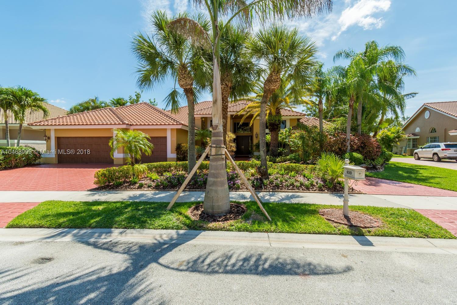 450 Alexandra Circle Weston, FL 33326 - Photo 3 of 84 a front view of a house with a garden and tree