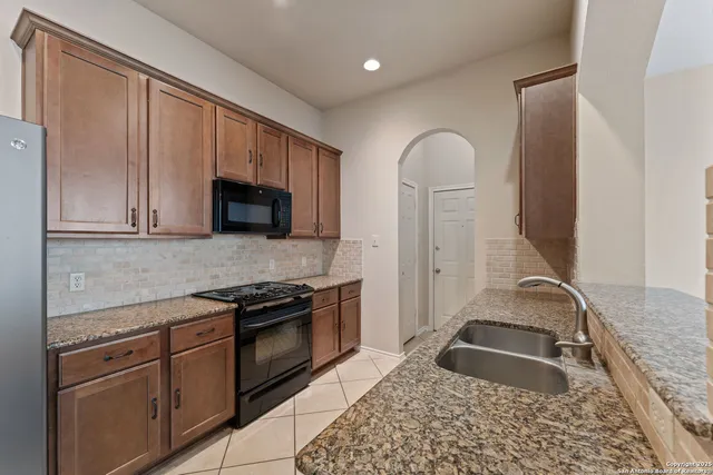 a kitchen with granite countertop stainless steel appliances a stove sink and microwave