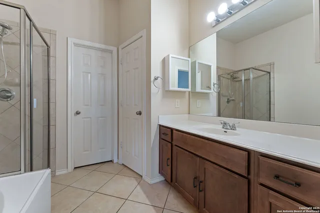 a bathroom with a shower sink and mirror
