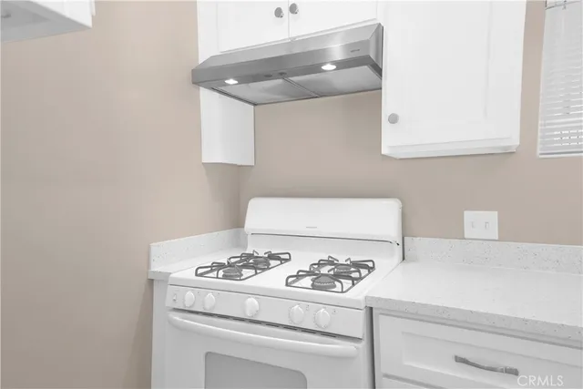 a kitchen with white cabinets and appliances