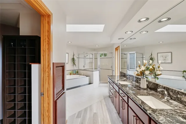 a large bathroom with a granite countertop double vanity sink a mirror and shower