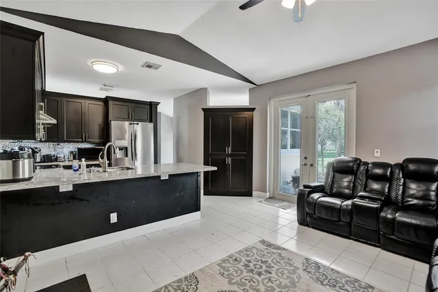 a large living room with stainless steel appliances granite countertop a couch and a view of living room
