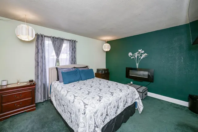 a bedroom with a bed dresser and a window