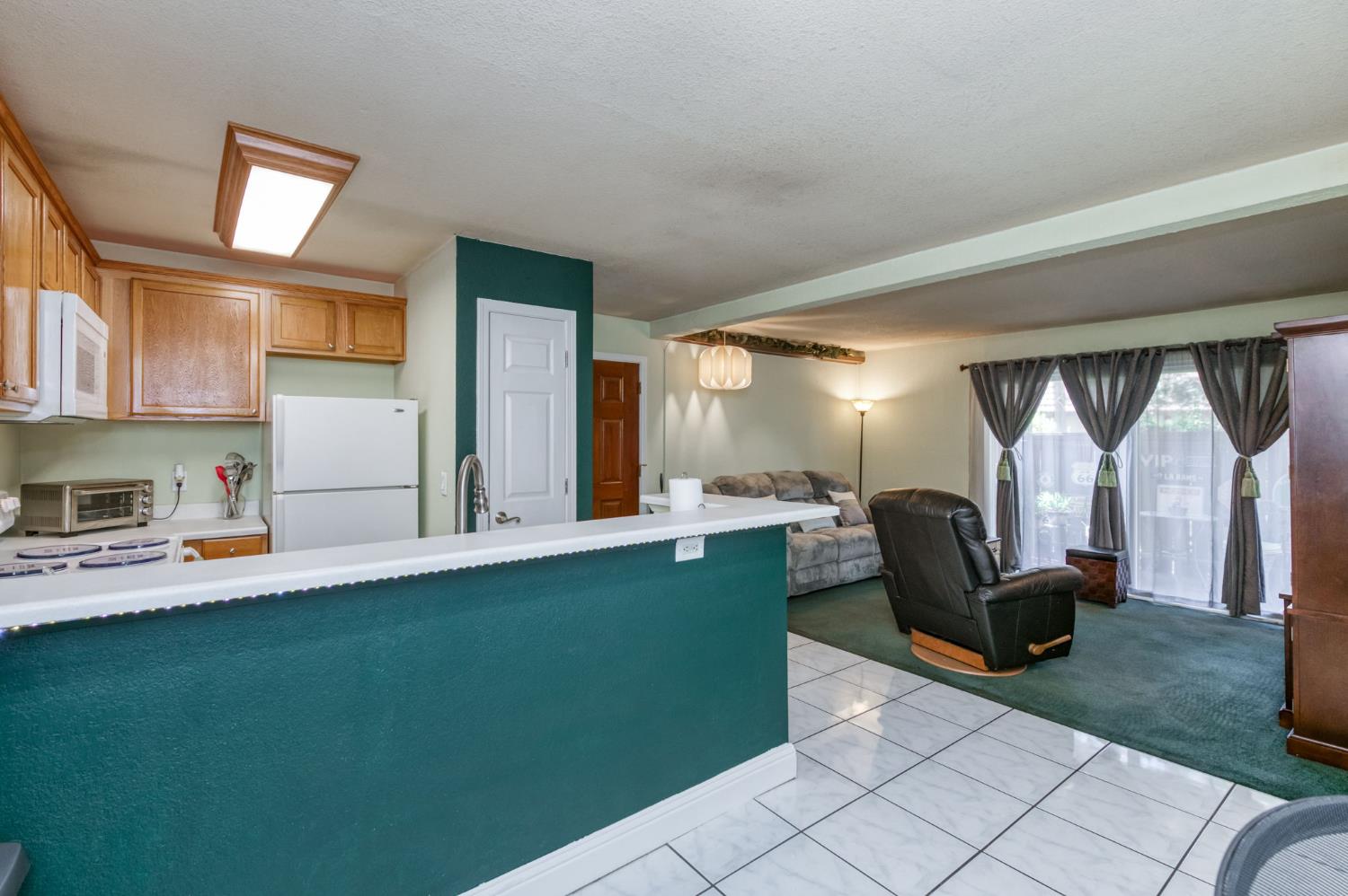 2909 Huntington Boulevard, Unit 145 Fresno, CA 93721 - Photo 7 of 33 a living room with furniture and a open kitchen view