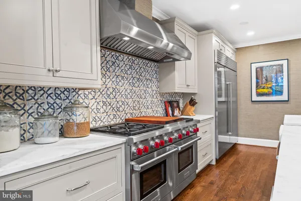 a utility room with stainless steel appliances and a wooden floor