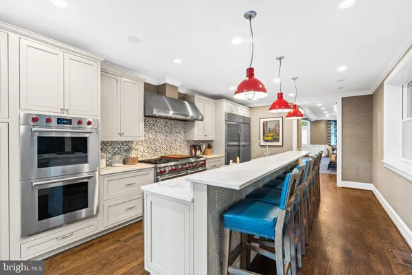 a view of a kitchen with kitchen island a stove a sink and a refrigerator