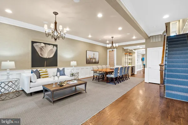 a living room with furniture a chandelier and a window