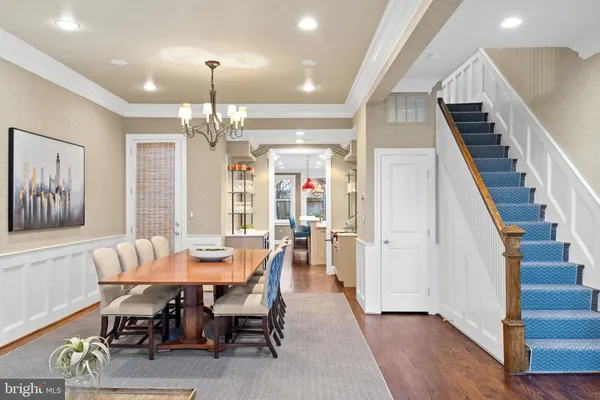 a view of a dining room with furniture a chandelier and wooden floor