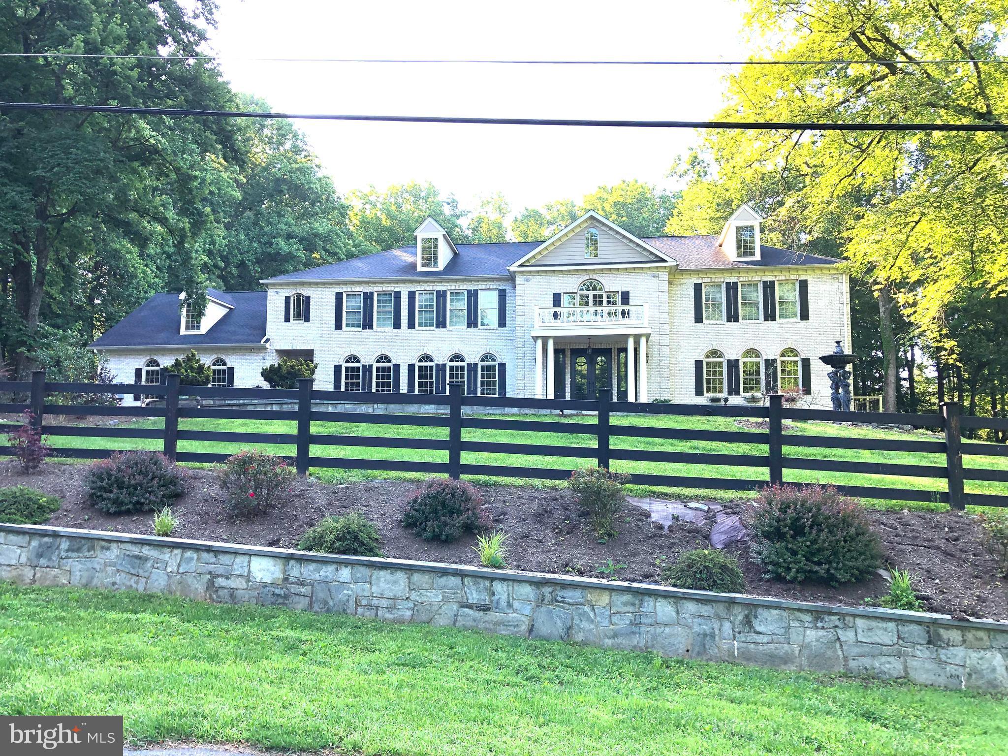 10813 Lockland Road Potomac, MD 20854 - Photo 1 of 73 a view of a house with a big yard and large trees