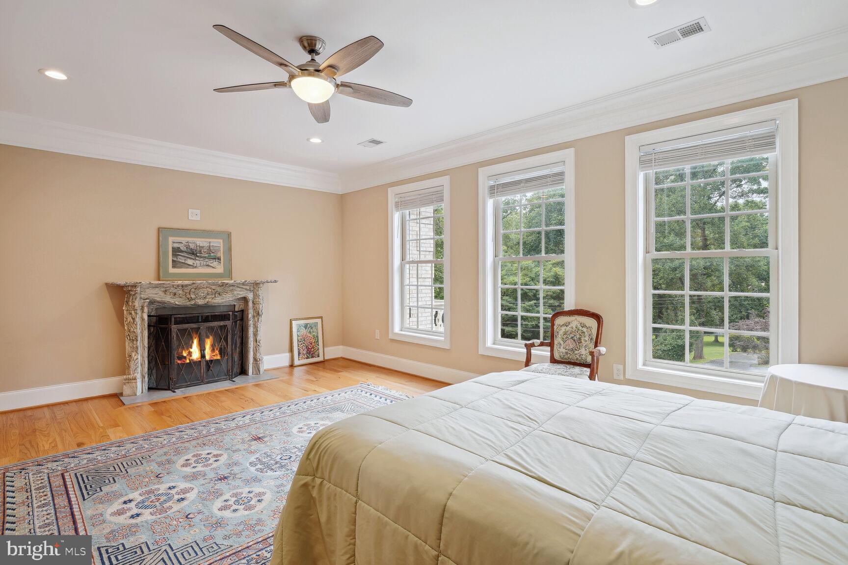 10813 Lockland Road Potomac, MD 20854 - Photo 42 of 73 a bedroom with a large bed and a fireplace
